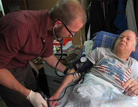 A man taking another man's blood pressure