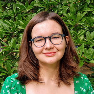 Woman with brown hair and glasses smiling at the camera