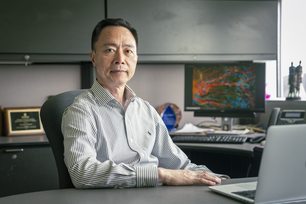 Su-Chun Zhang, MD, PhD sitting at his desk lookinf at the camera