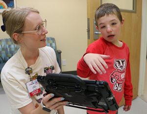 Therapist and boy using AAC