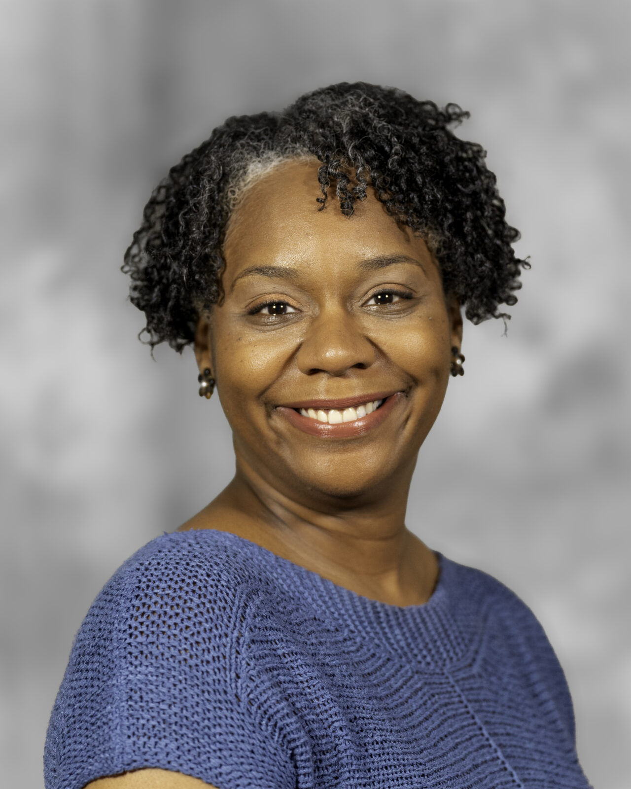 A black woman with short hair smiling
