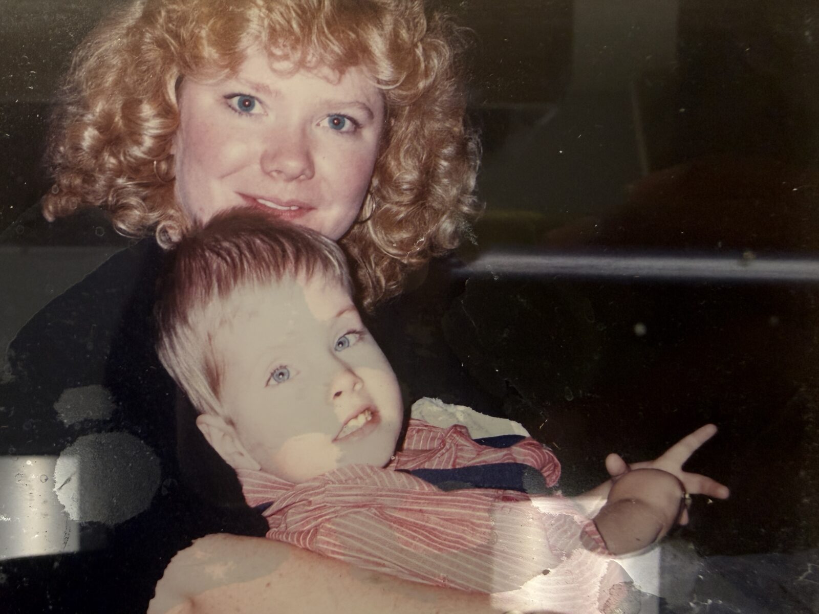 Linda holds young Mitchell while they both smile at the camera